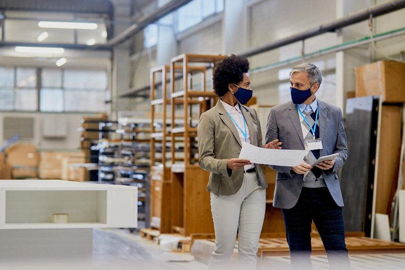 company-managers-with-protective-face-masks-talking-while-walking-through-wood-factory-facility (1)