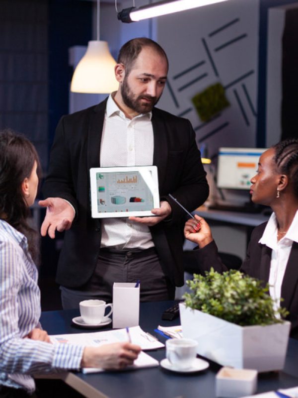 overworked-businessman-showing-financial-graphs-presentation-using-tablet-brainstorming-company-ideas (1)